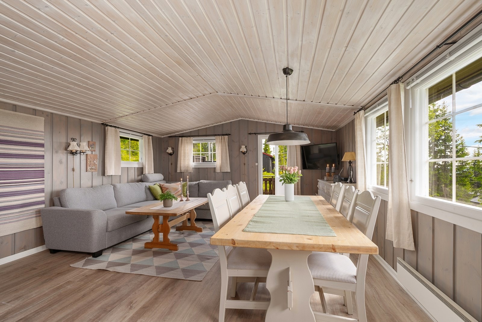 Oppholdsrommet i hytta er lunt og innbydende med plass til både langbord og sofa. Galleribilde