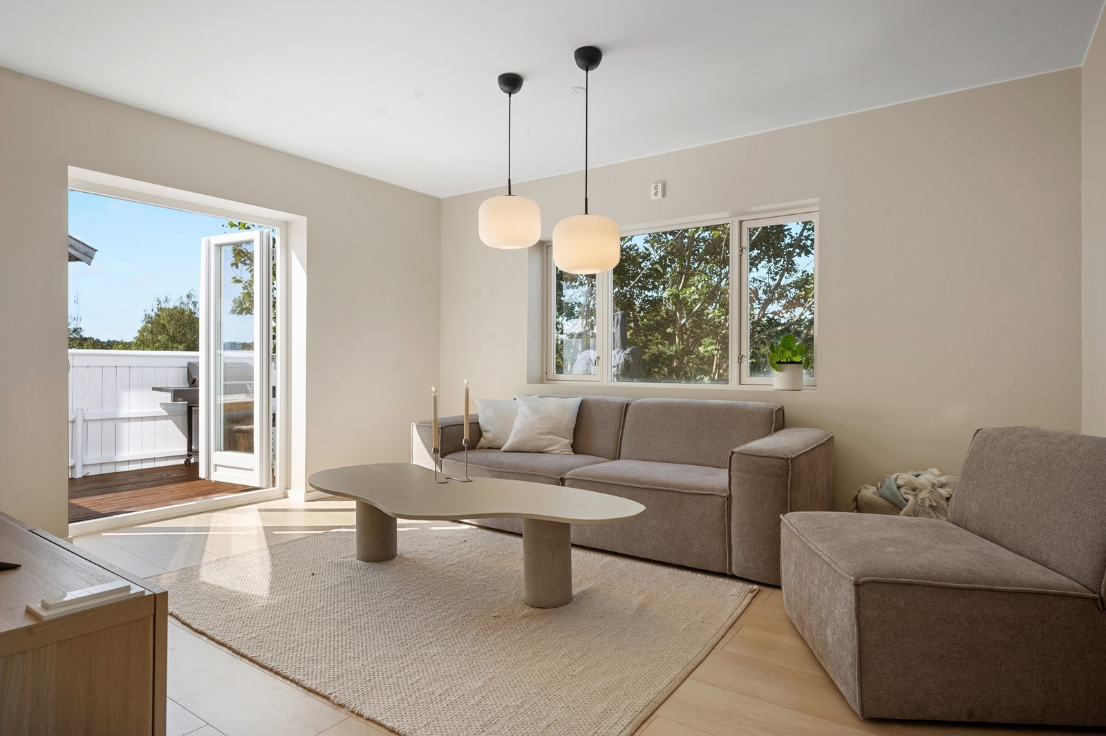 Doble dører ut til solfylt veranda samt listfrie vegger mot himlingen Galleribilde