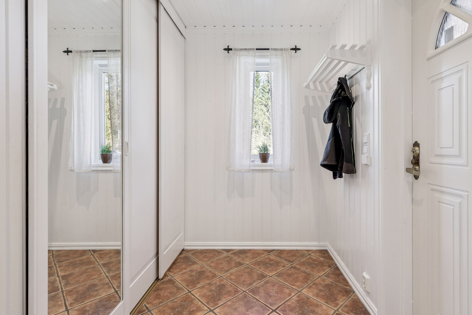 Entré med skyvedørsgarderobe og fliser med varme i gulv! Galleribilde