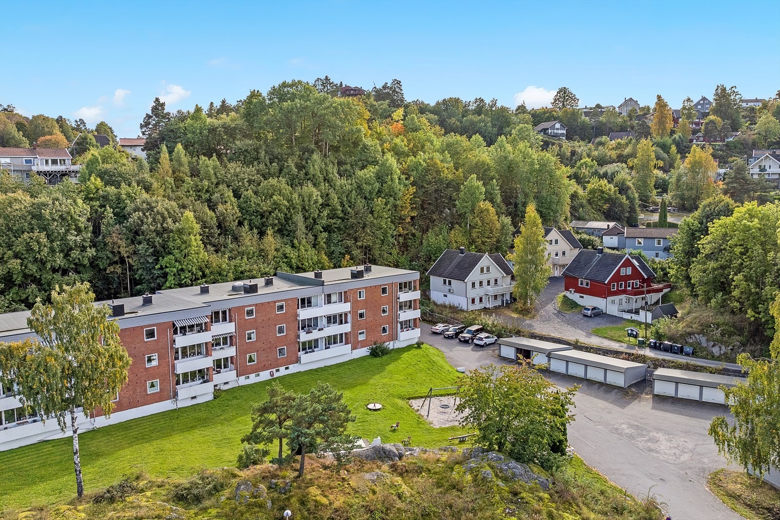 Asfaltert fellesparkering, samt felles gressplen i front av blokka. Galleribilde