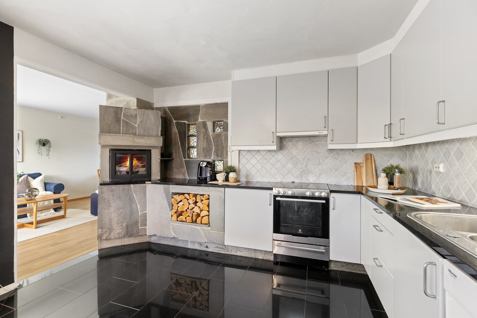 Kjøkkenet har en robust peisovn med glassdør, som gir både varme og atmosfære. Galleribilde