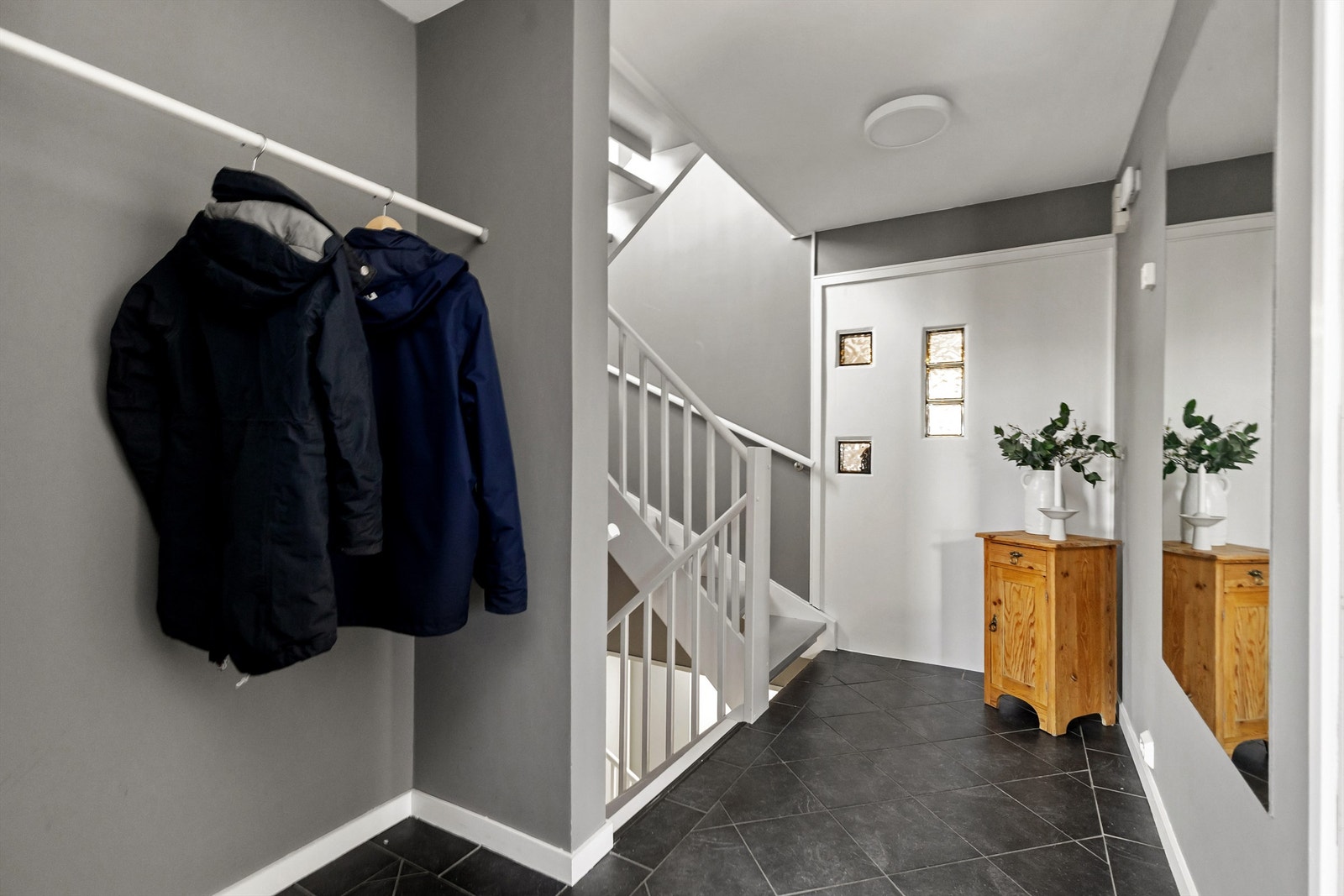 Fra gangen leder en solid tretrapp videre til boligens øvrige etasjer. Galleribilde
