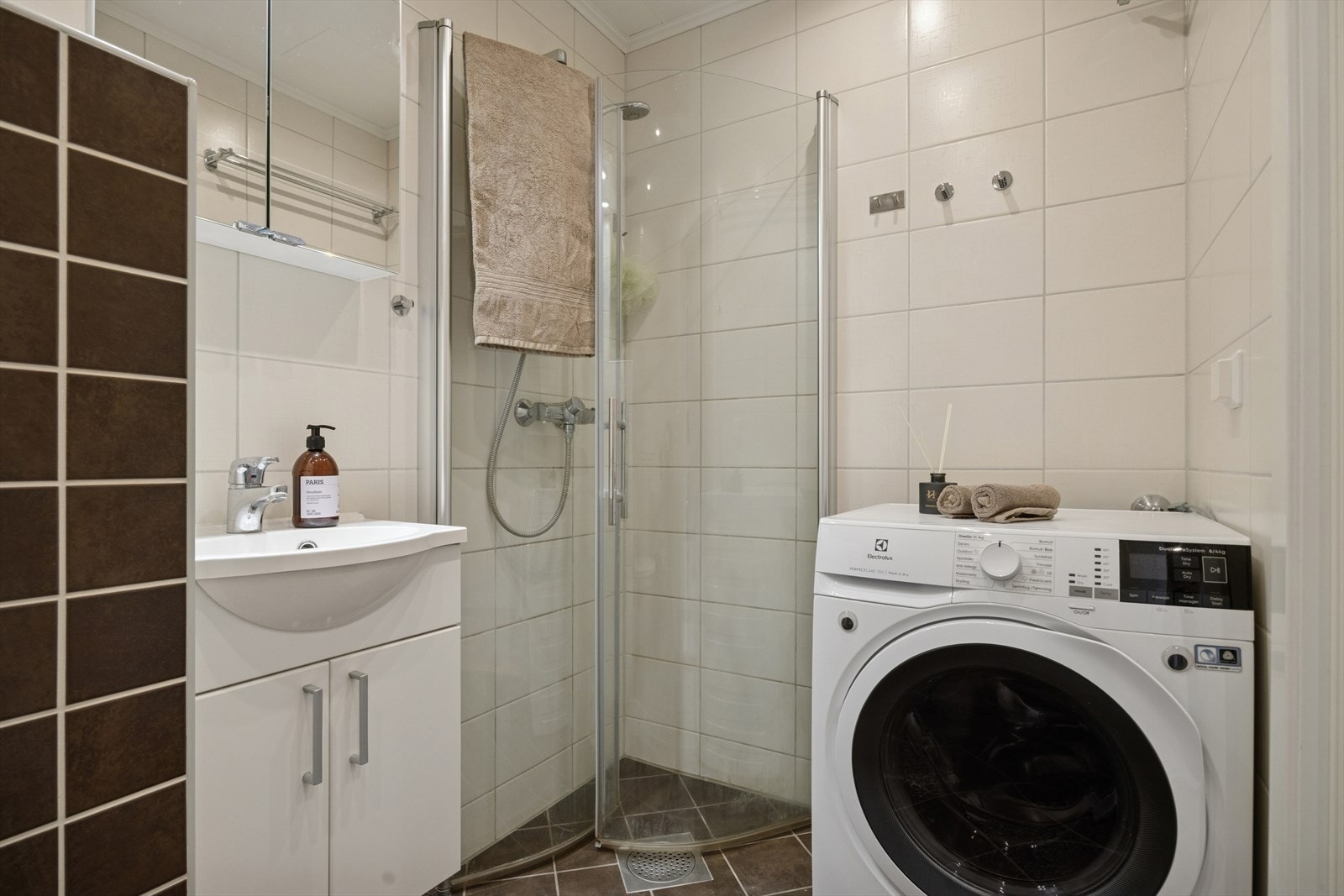 Bad (2,7m²): Flislagt bad med varmekabler, dusjhjørne, servant med underskap og opplegg for vaskemaskin. Galleribilde