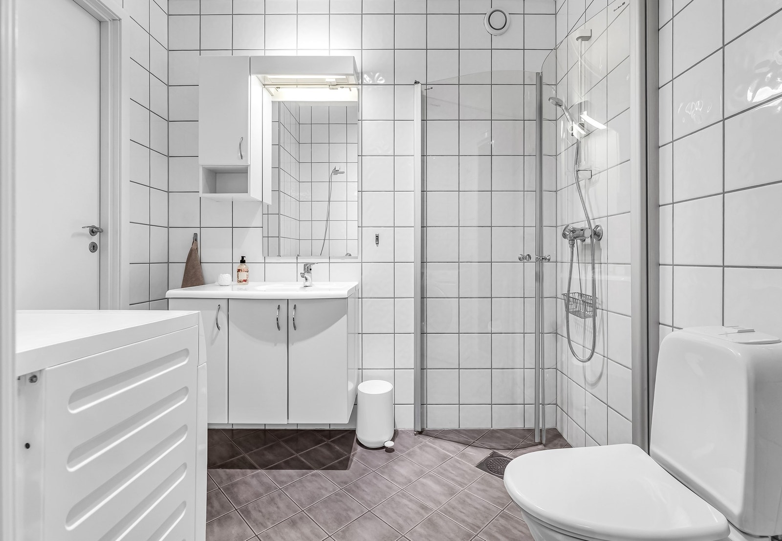 Speil, vegghengt skap og belysning over servant. Galleribilde