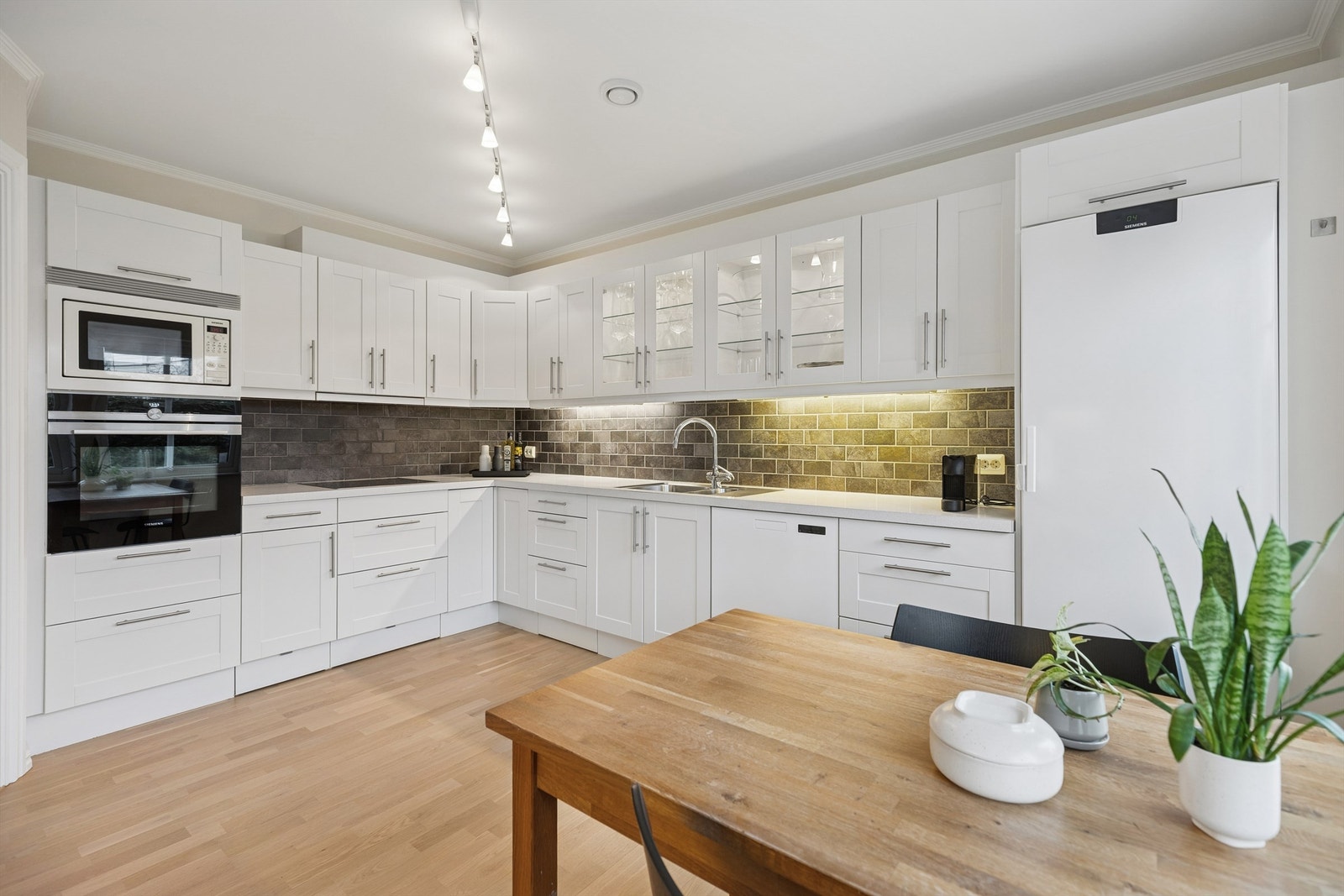 Integrerte hvitevarer som induksjonstopp, stekeovn og microovn, samt separat oppvaskmaskin og kjøle-/fryseskap medfølger. Galleribilde