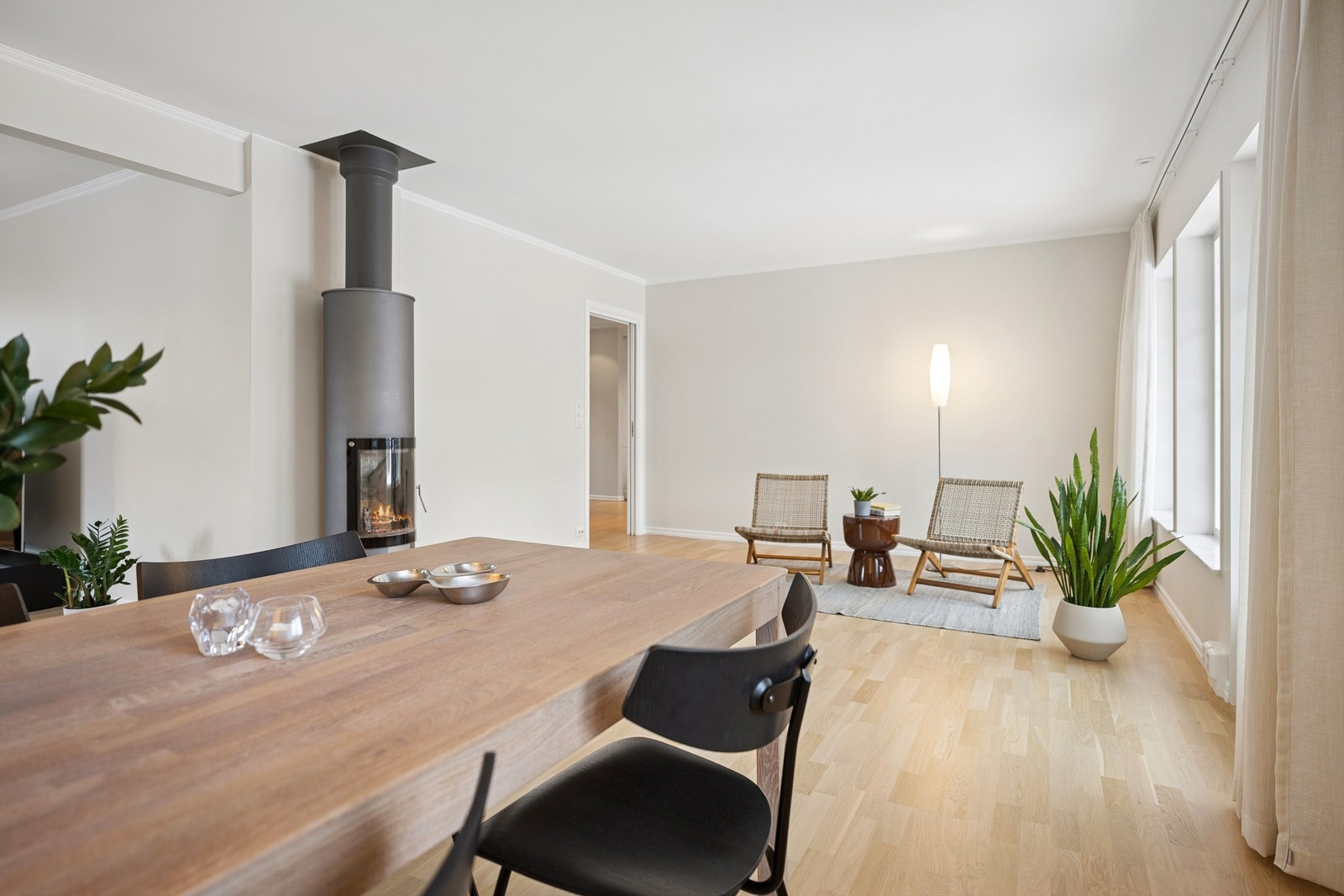 Peisen fungerer som en naturlig romdeler og skaper en fin avgrensning mellom de ulike sonene i stuen. Galleribilde