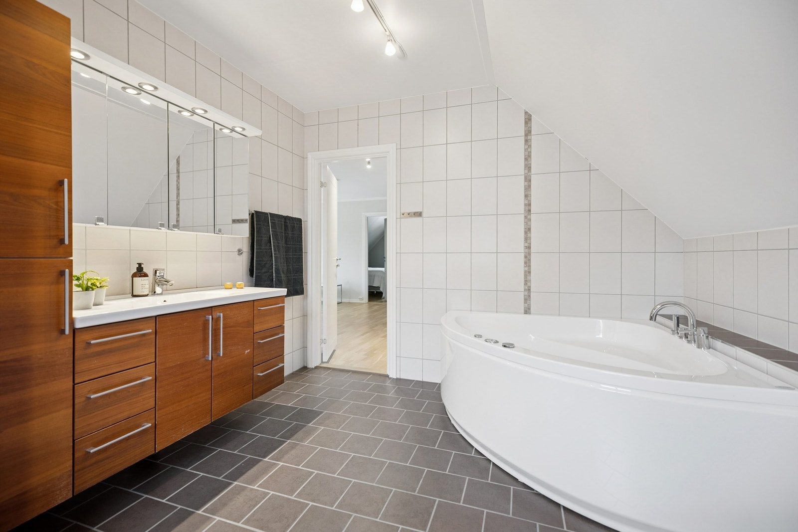 Lekkert flislagt bad i 2. etasje med massasjebadekar, dusjnisje med regndusj og rikelig med baderomsinnredning. Galleribilde