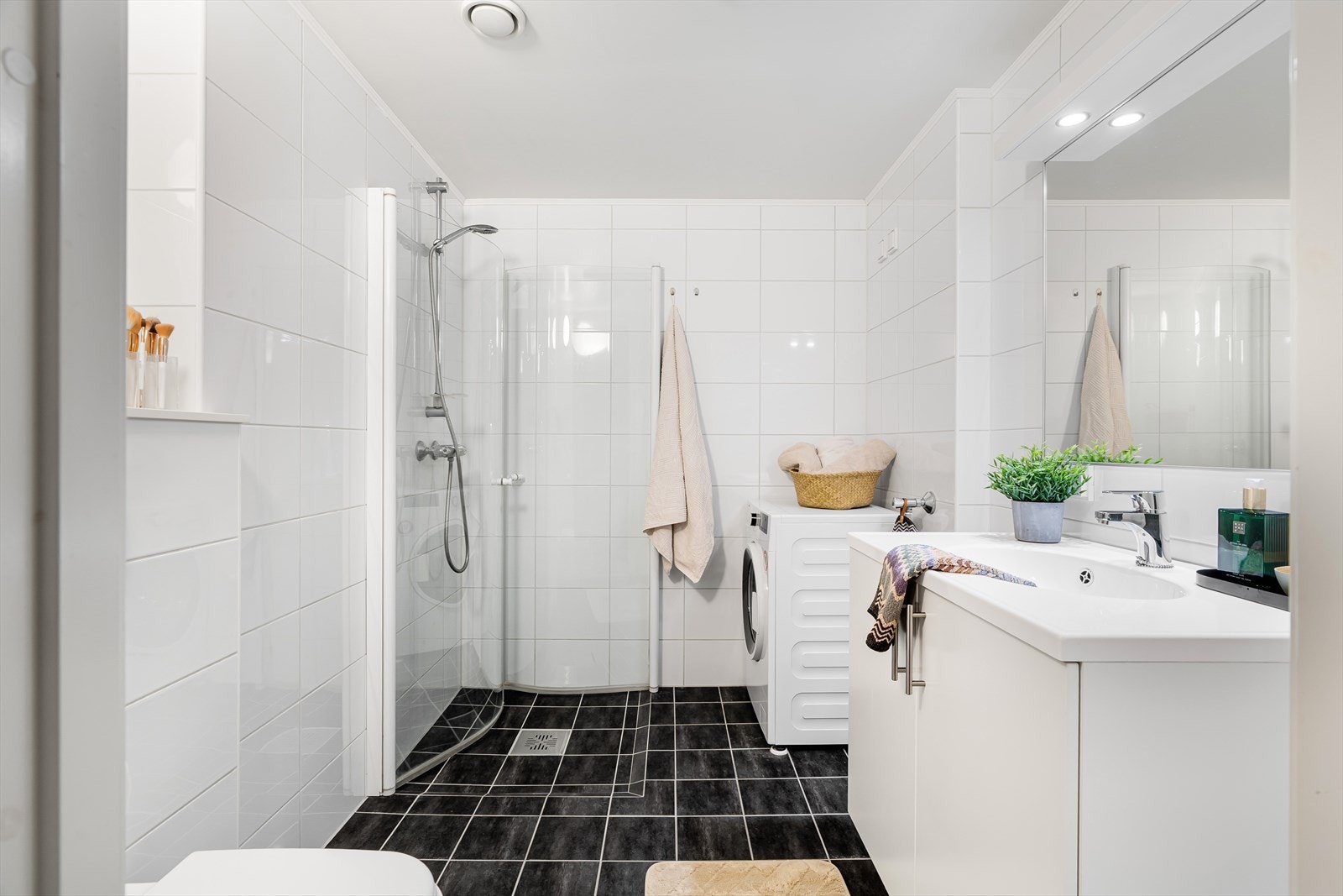 Her finner du dusjhjørne, toalett, opplegg for vaskemaskin samt en praktisk baderomsinnredning med servantskap. Galleribilde