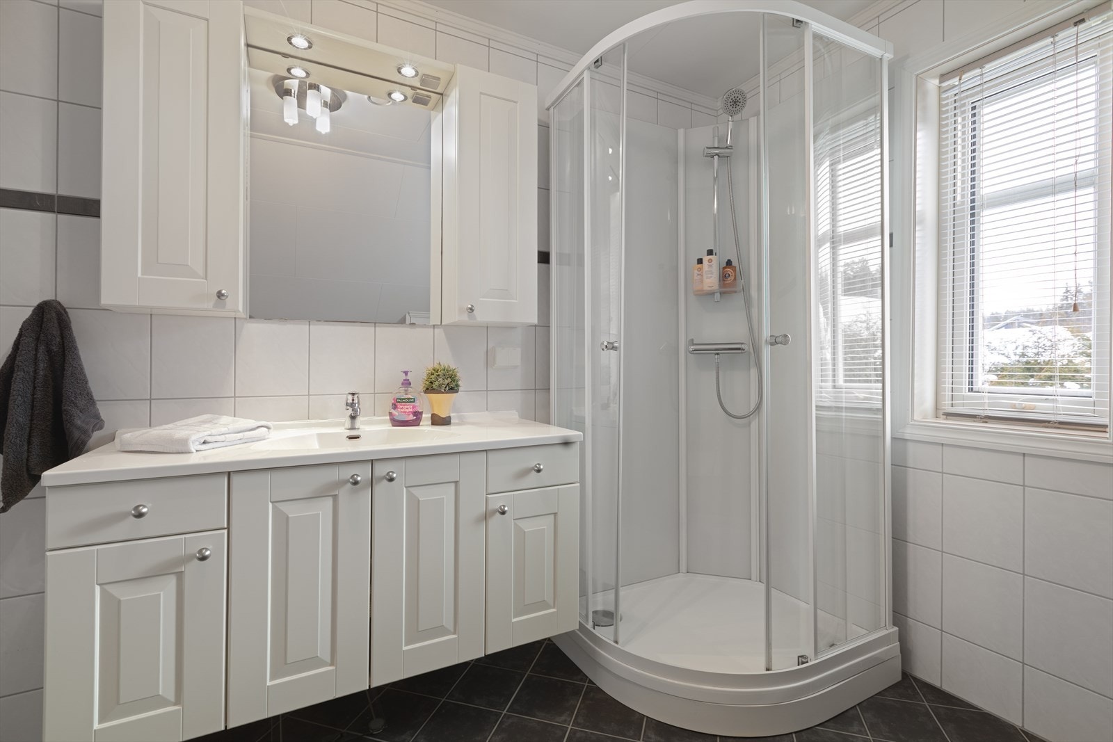 Hvit, profilert baderomsinnredning med god oppbevaringsplass. Galleribilde