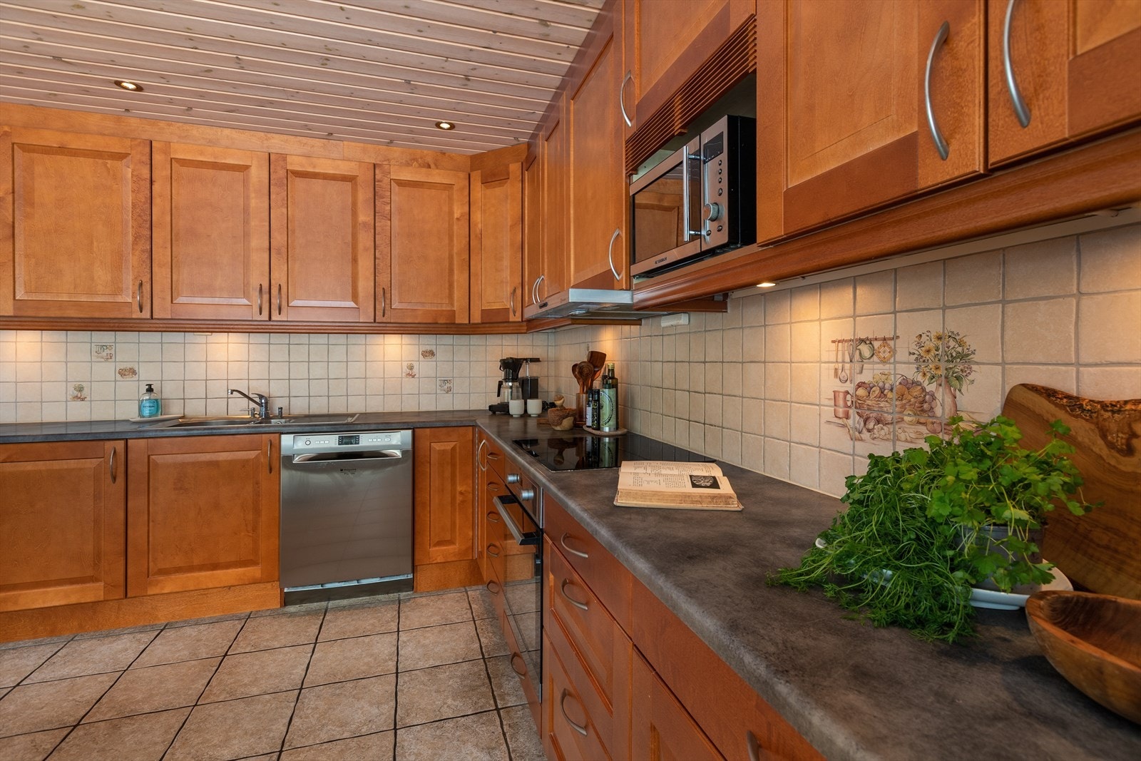 Laminert benkeplate gir rikelig med arbeidsflate. Kjøkkenventilator med avtrekk ut ble installert i 2022. Galleribilde