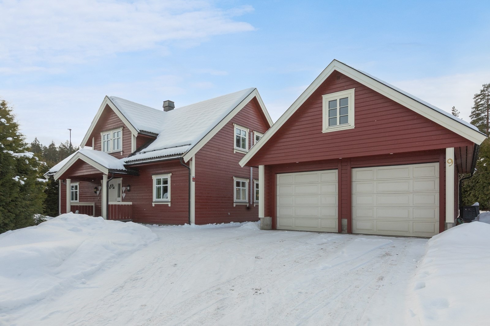 Enebolig fra 2005 med en flat, opparbeidet tomt med plenarealer og prydbusker. Galleribilde