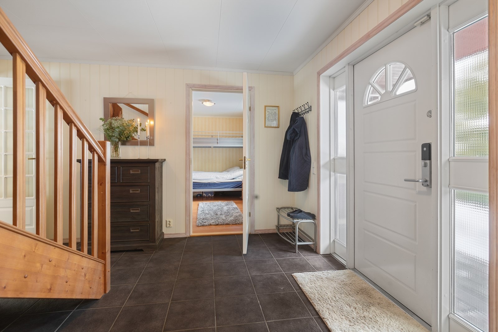 Velkommen inn i en romslig entré med flislagt gulv og adkomst til ett av soverommene. Galleribilde