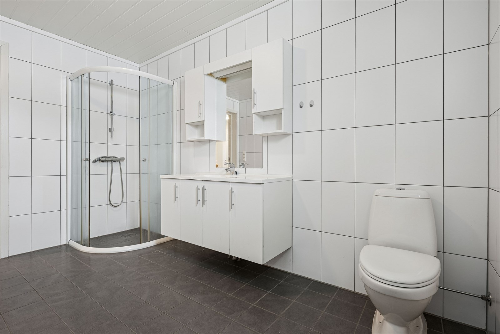 Lekkert og lyst baderom fra byggeår med fliser på gulv og vegger. Galleribilde