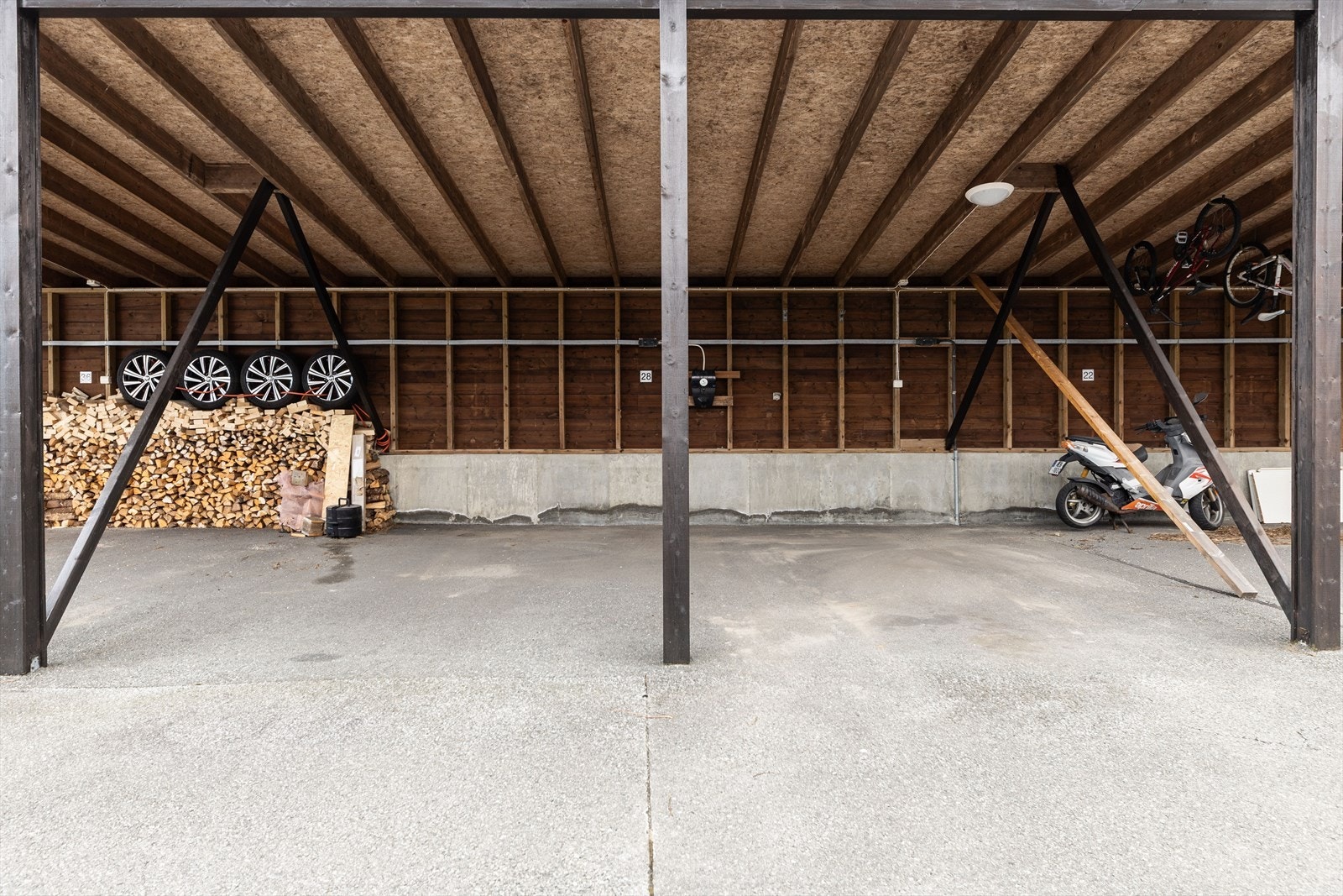 Boligen har to parkeringsplasser med elbillader i felles carport. Galleribilde