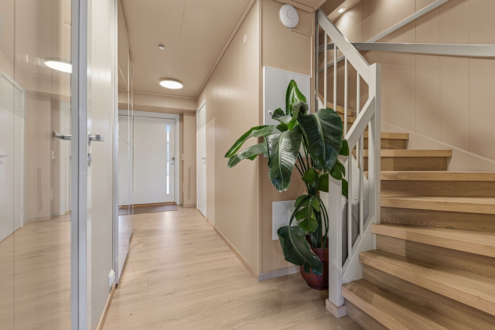 Man ønskes velkommen inn i en lys og romslig gang som er praktisk innredet med stor skyvedørsgarderobe hvor man har god plass til å henge fra seg yttertøy og sko. Galleribilde