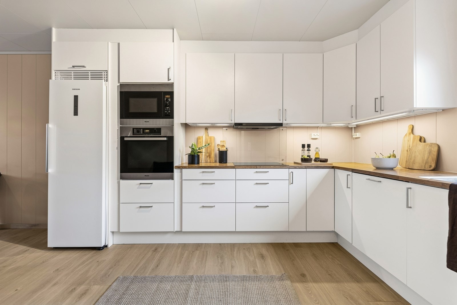 Kjøkkenet er ellers utstyrt med frittstående kjøleskap, oppvaskmaskin, stekeovn, mikrobølgeovn, induksjonstopp og kjøkkenventilator med avtrekk ut. I tillegg er det installert komfyrvakt. Galleribilde