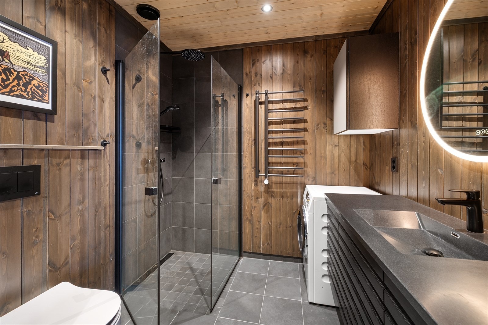 Bad nr. 2 er strategisk plassert i gangen mellom soverom nr. 2 og kjøkken/stue. Badet har panelkledde vegger, med fliser i dusjsonen og opplegg for vaskemaskin. Galleribilde