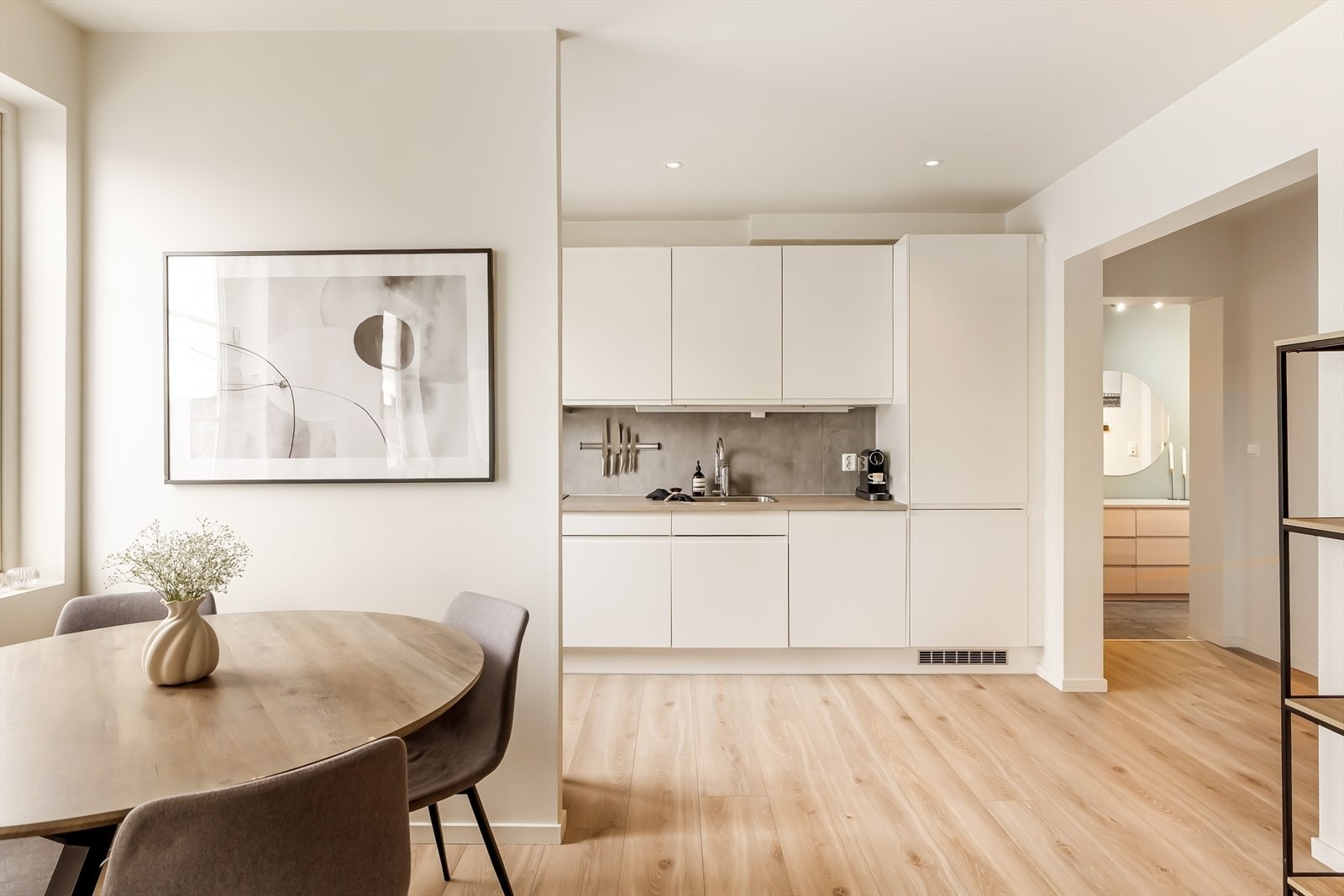 En skillevegg mellom kjøkken og spiseplass bidrar samtidig til å skape naturlige og tydelige soner i rommet, slik at man enkelt kan innrede etter eget ønske. Galleribilde