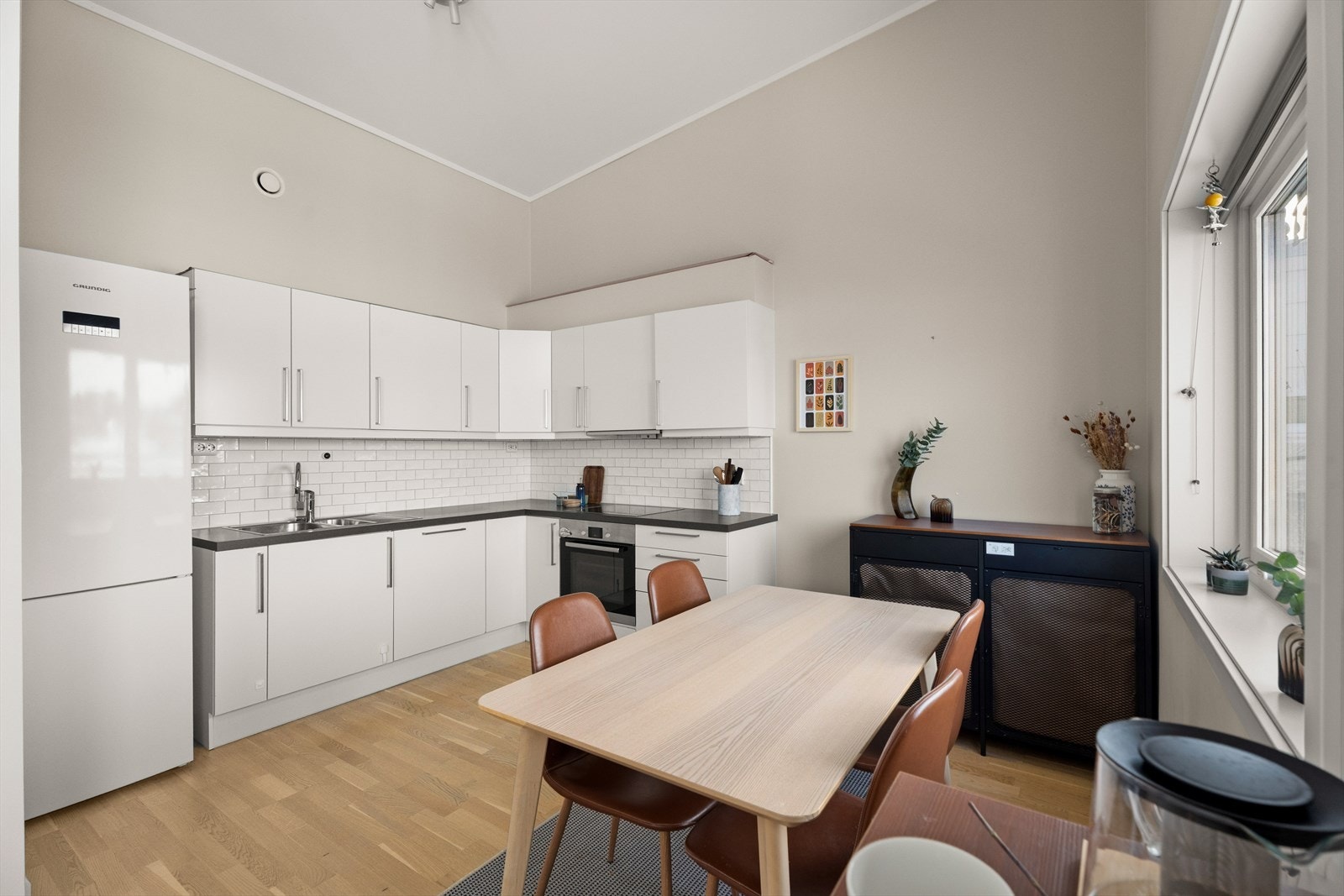 Kjøkkenet er praktisk utformet med hvite, glatte fronter og god skapplass. Galleribilde