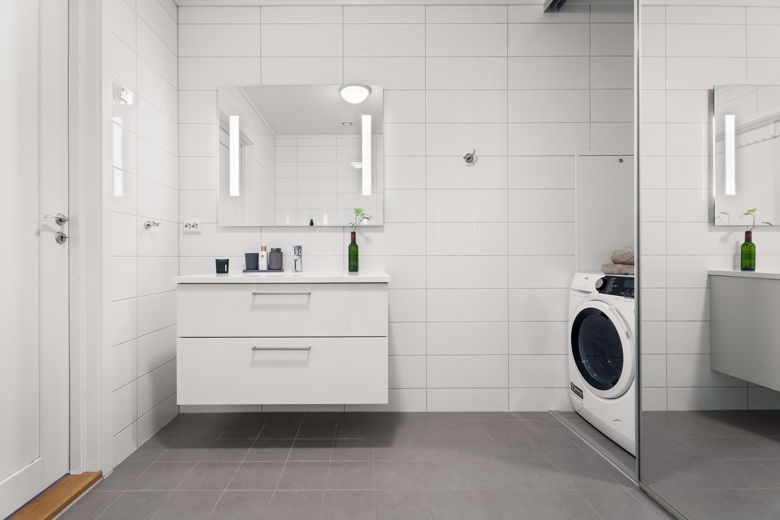 Baderomsinnredningen har en bred servant med skuffer og et stort speil med integrert belysning. Galleribilde