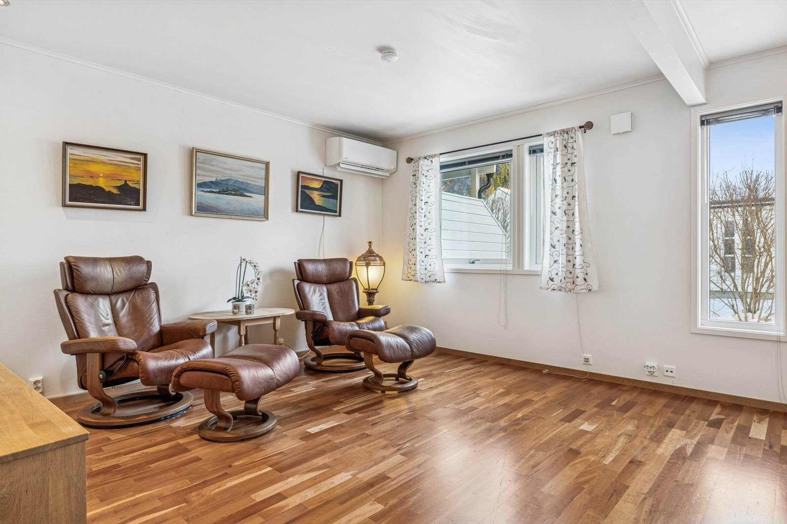 Parkettgulv og store vinduer gir rommet et lyst preg. Galleribilde