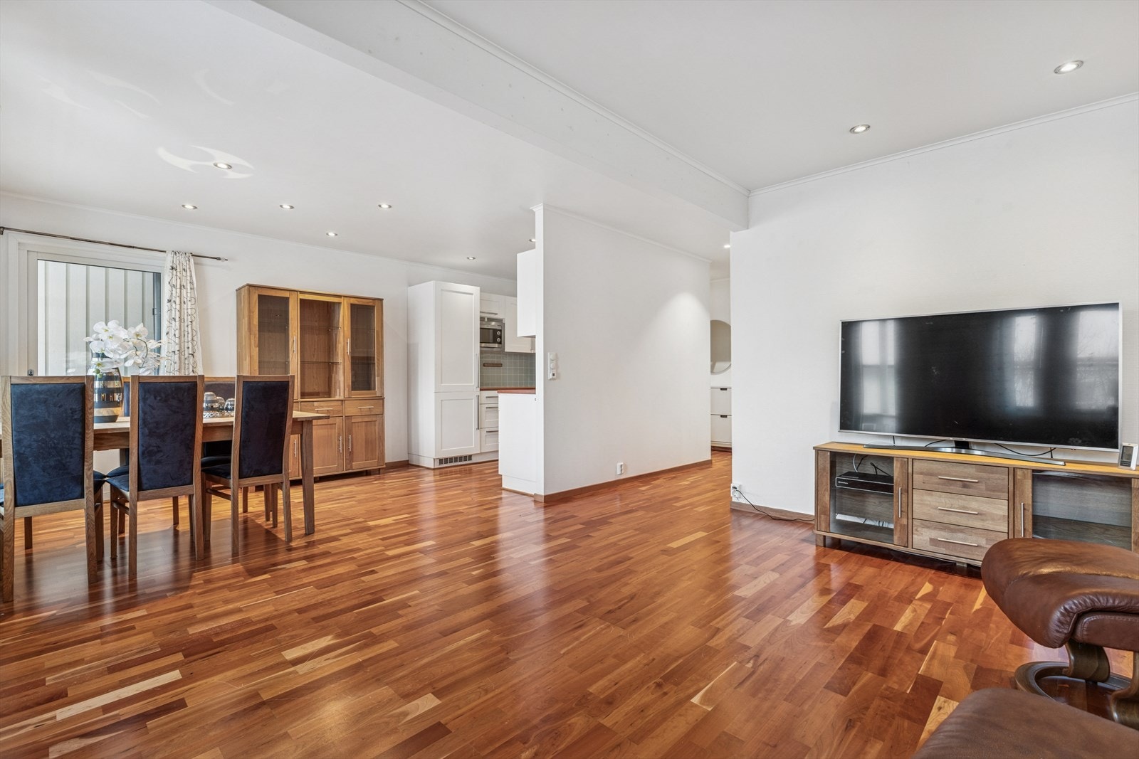 Stue med parkettgulv og store vindusflater gir godt lysinnslipp. Galleribilde