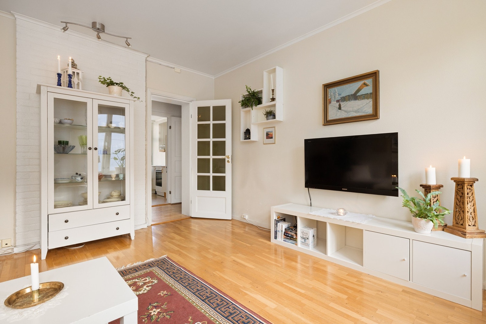 Stuen har velholdt parkett på gulv og lysmalt strietapet på veggene. Galleribilde