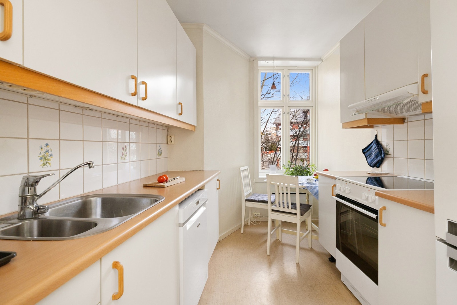 Innredningen har hvite glatte fronter og laminert benkeplate med nedfelt oppvaskkum. Galleribilde