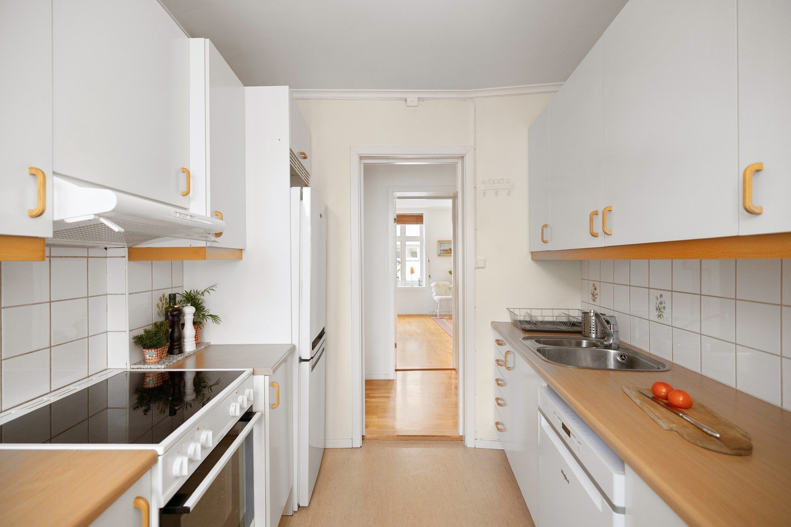 Praktisk med lyse fliser i benkeryggen og belysning under overskapene. Galleribilde