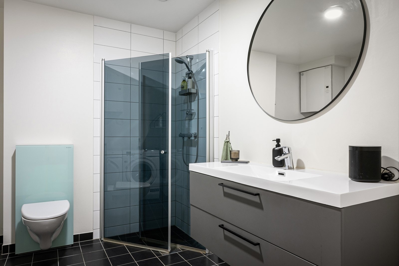 Badet fremstår som romslig med pen baderomsinnredning i grå utførelse. Galleribilde