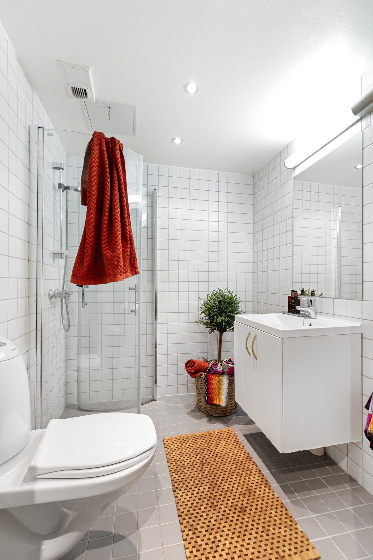 Moderne flislagt bad med opplegg for vaskemaskin Galleribilde