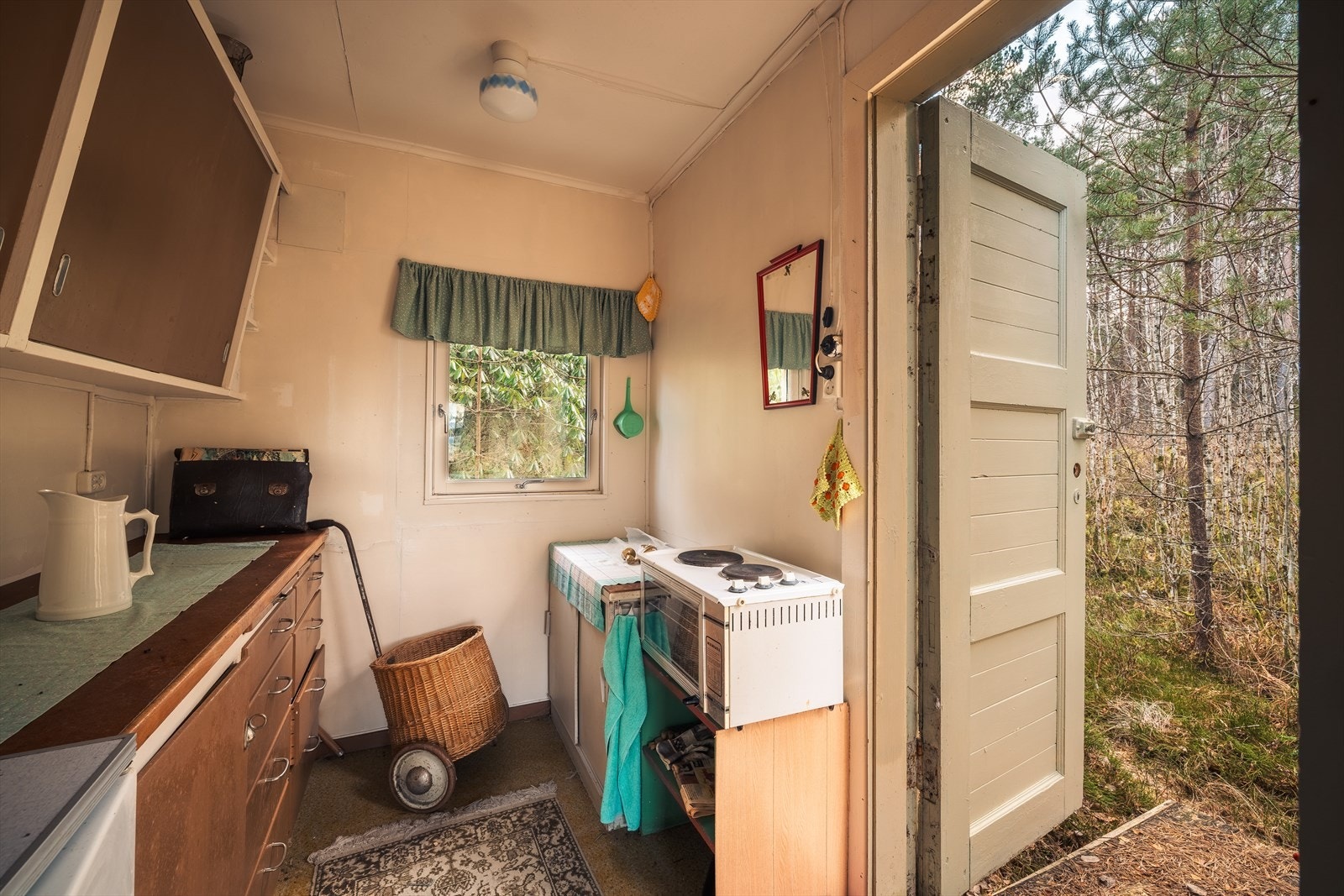 Kjøkkenet har et areal på 4,4m². Her er vinylbelegg på gulv, malt platekledning på vegger og i himling. Kjøkkeninnredning med slette fronter og benkeplate av huntonit. Galleribilde