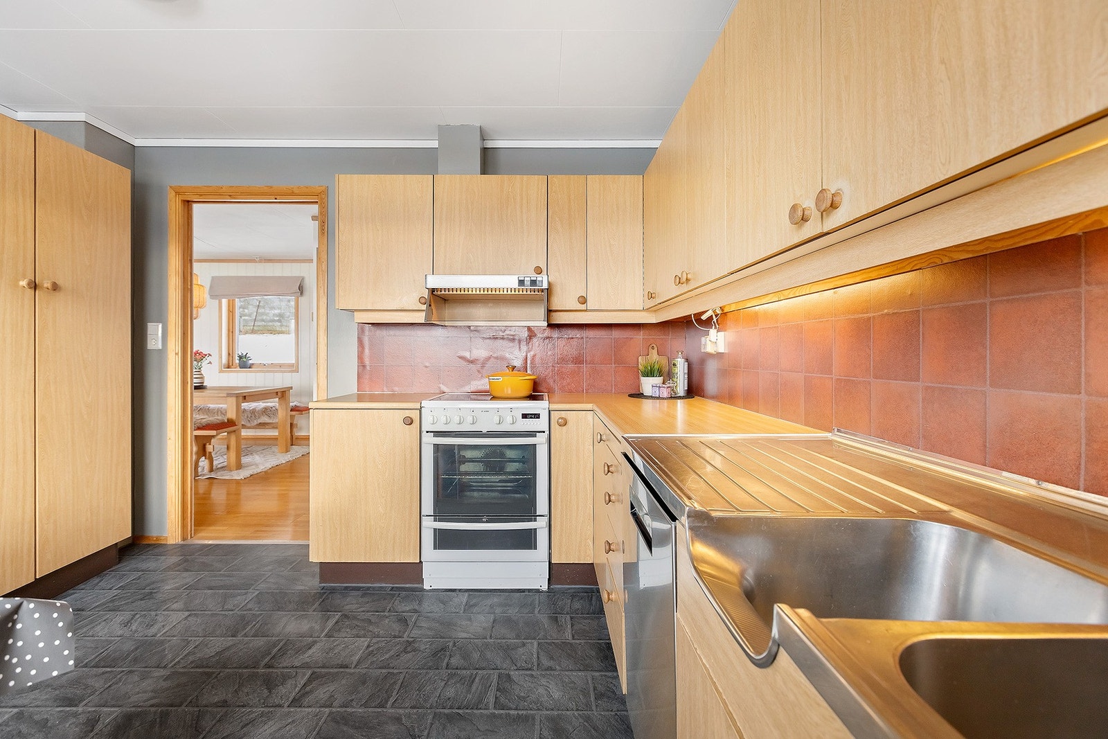 Kjøkkenet har laminat på gulv og malte vegger. Kjøkkeninnredning er fra byggeår. Galleribilde