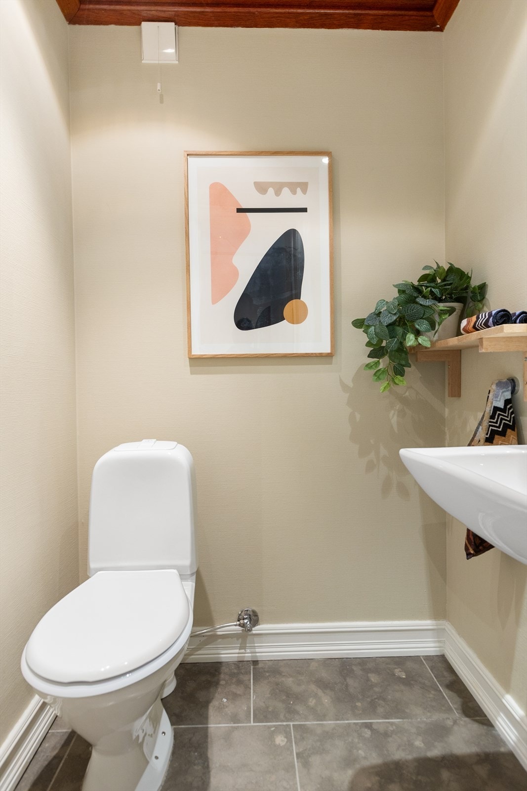 Separat toalettrom/gjestetoalett med flislagt gulv, elektriske varmekabler og malte veggflater Galleribilde