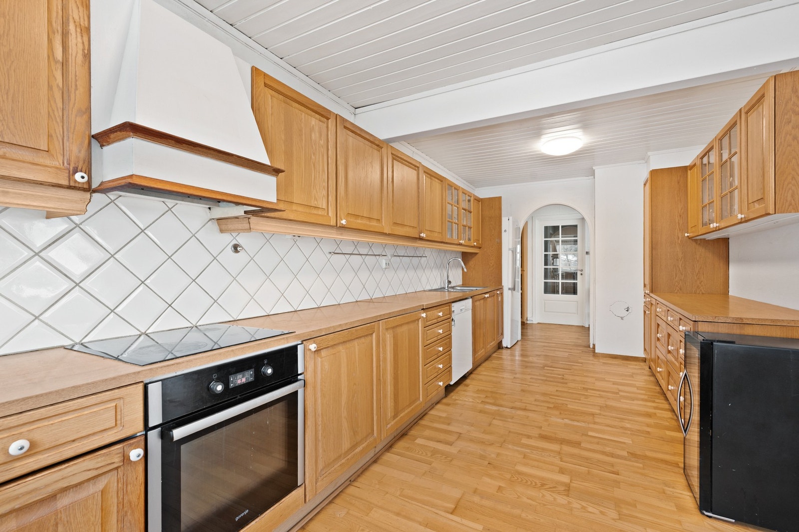 Romslig kjøkken med svært god skap- og benkeplass. Her medfølger integrert stekeovn, platetopp og oppvaskmaskin. I tillegg følger fryseskap i bod og et sort kjøl/frys Galleribilde