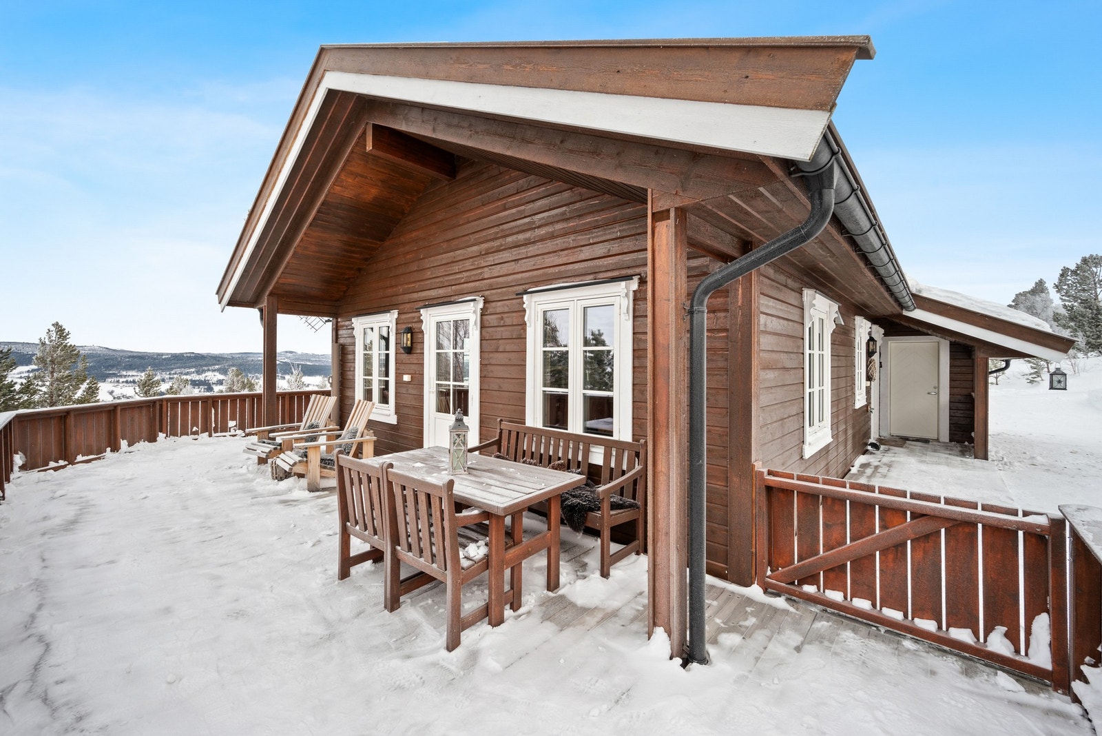 Fra stua er det utgang til terrassen som strekker seg rundt to av sidene på hytta. Galleribilde