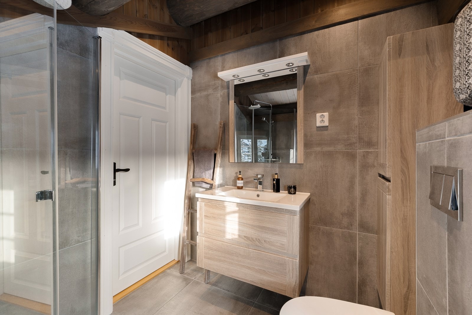 Innredningen består av servant med underskap, speilskap og vegghengt toalett. Galleribilde