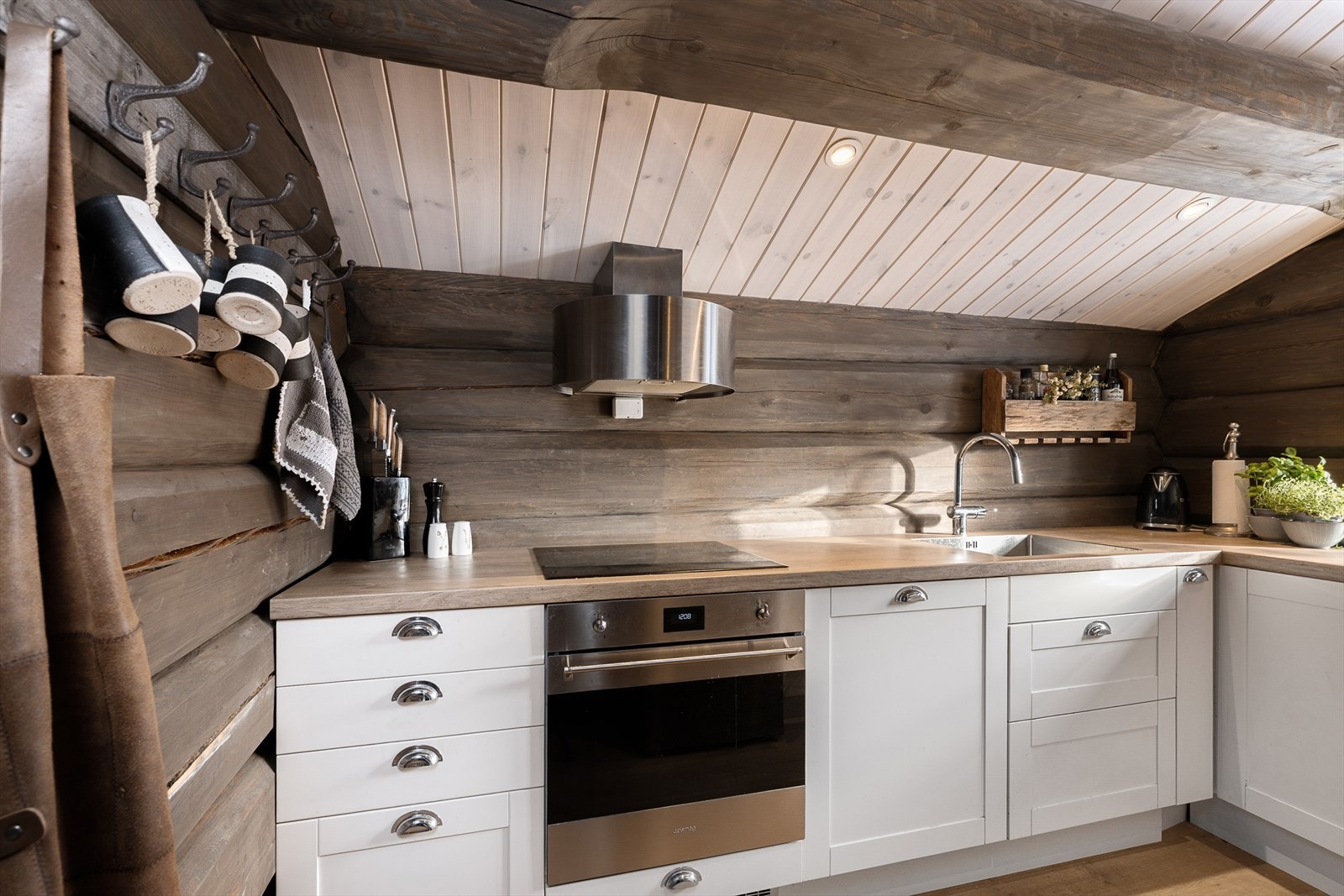 Kombinasjonen av tømmervegger og moderne utstyr gir kjøkkenet særpreg. Galleribilde