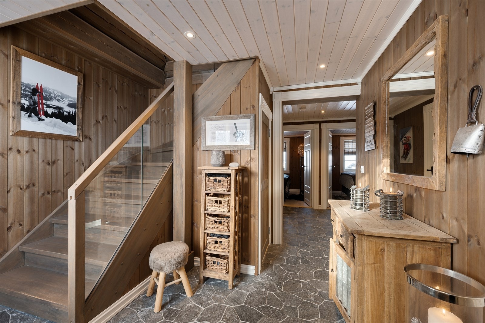 En solid tretrapp med rekkverk av tre og glass leder opp til hyttas sosiale sone. Galleribilde