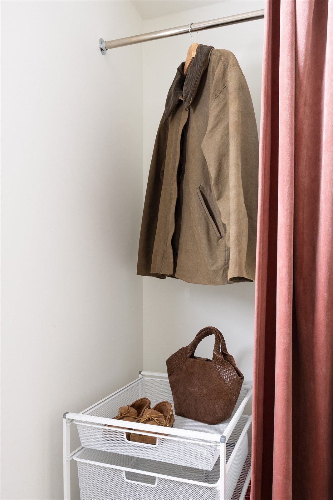 Smart garderobeløsning diskret gjemt bak et elegant forheng, som gir et ryddig og innbydende førsteinntrykk. Galleribilde