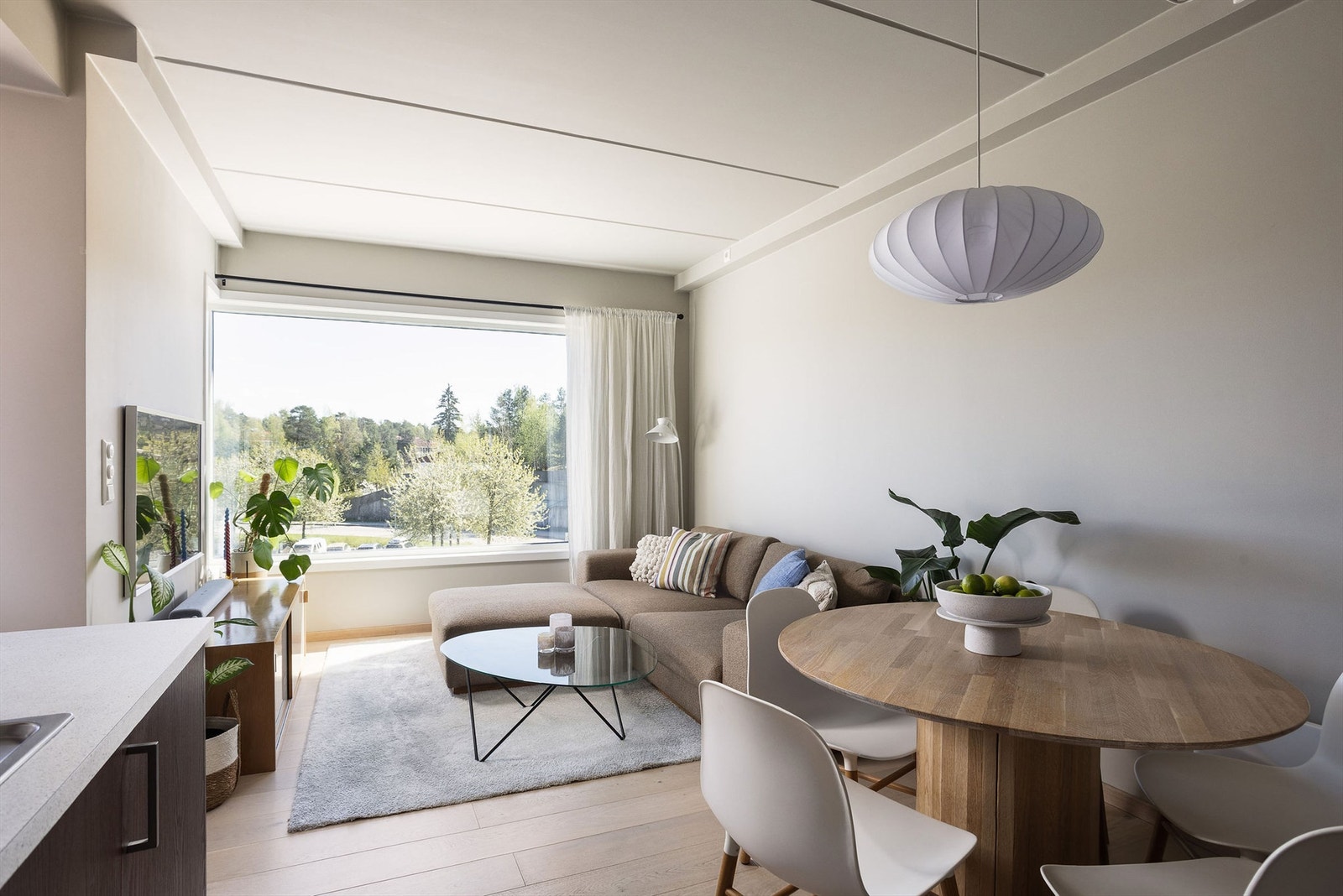 Stue, spisestue og kjøkken smelter sømløst sammen i en stilren og åpen løsning. Galleribilde