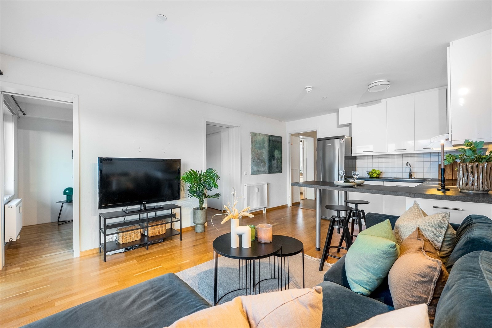 Stilren stue med plass til både sofagruppe og TV-bord i et åpent og lyst rom. Galleribilde