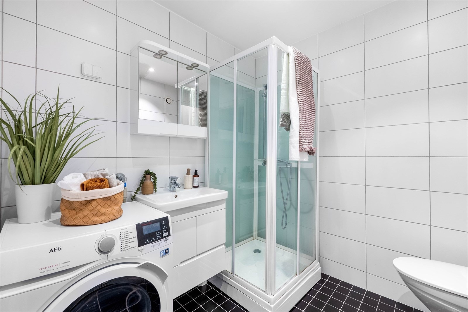 Innredningen består av heldekkende servant på skuffeseksjon, speilskap, dusjkabinett, wc og opplegg for vaskemaskin. Galleribilde