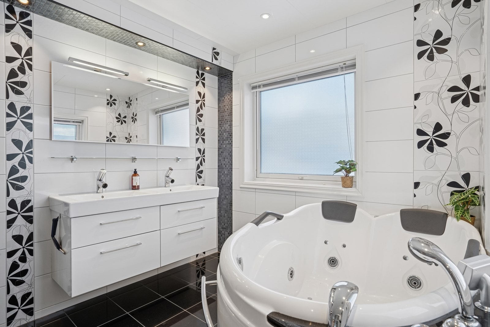 Baderommet i første etasje har innredning med heldekkende servanter og ett-greps blandebatteri, vegghengt speil med lys, vegghengt toalett, elektrisk håndkletørker, steamdusj og boblebad. Galleribilde