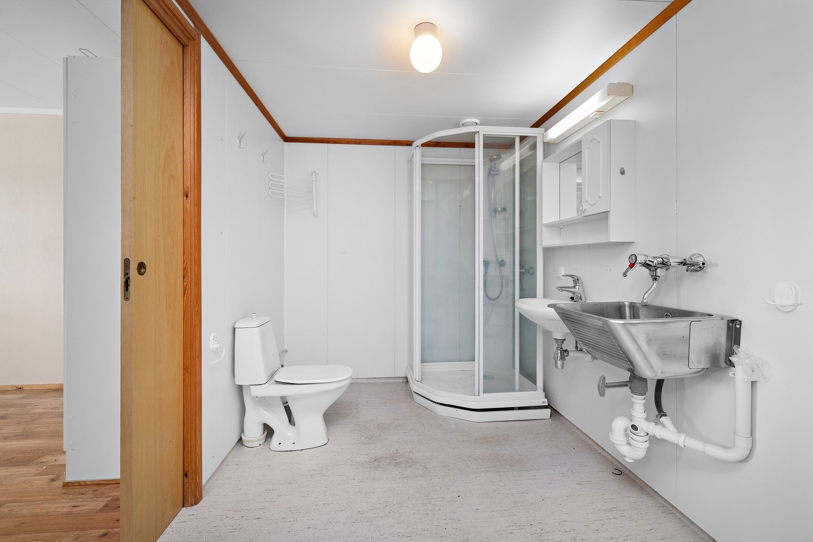 Rommet har baderomsplater på veggene, vinylbelegg på gulvet og mekanisk avtrekk, alt fra byggeår Galleribilde