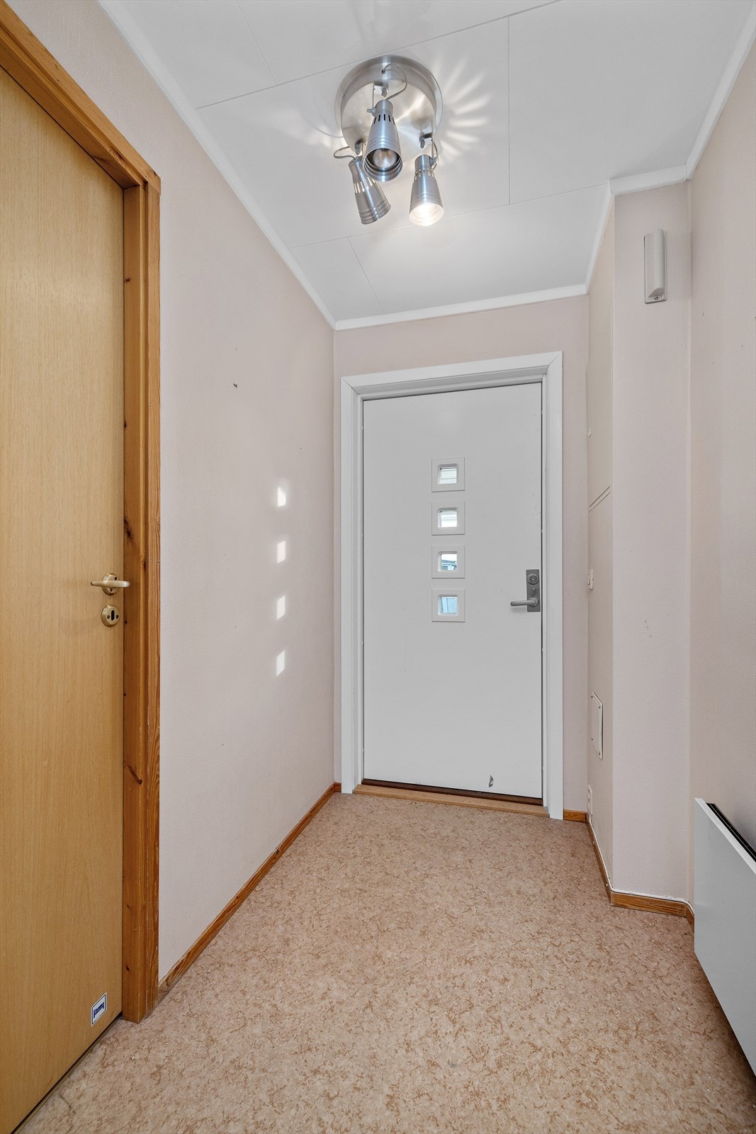 Inngangsdøren er i profilert utførelse og leder inn til en lys entré. Galleribilde