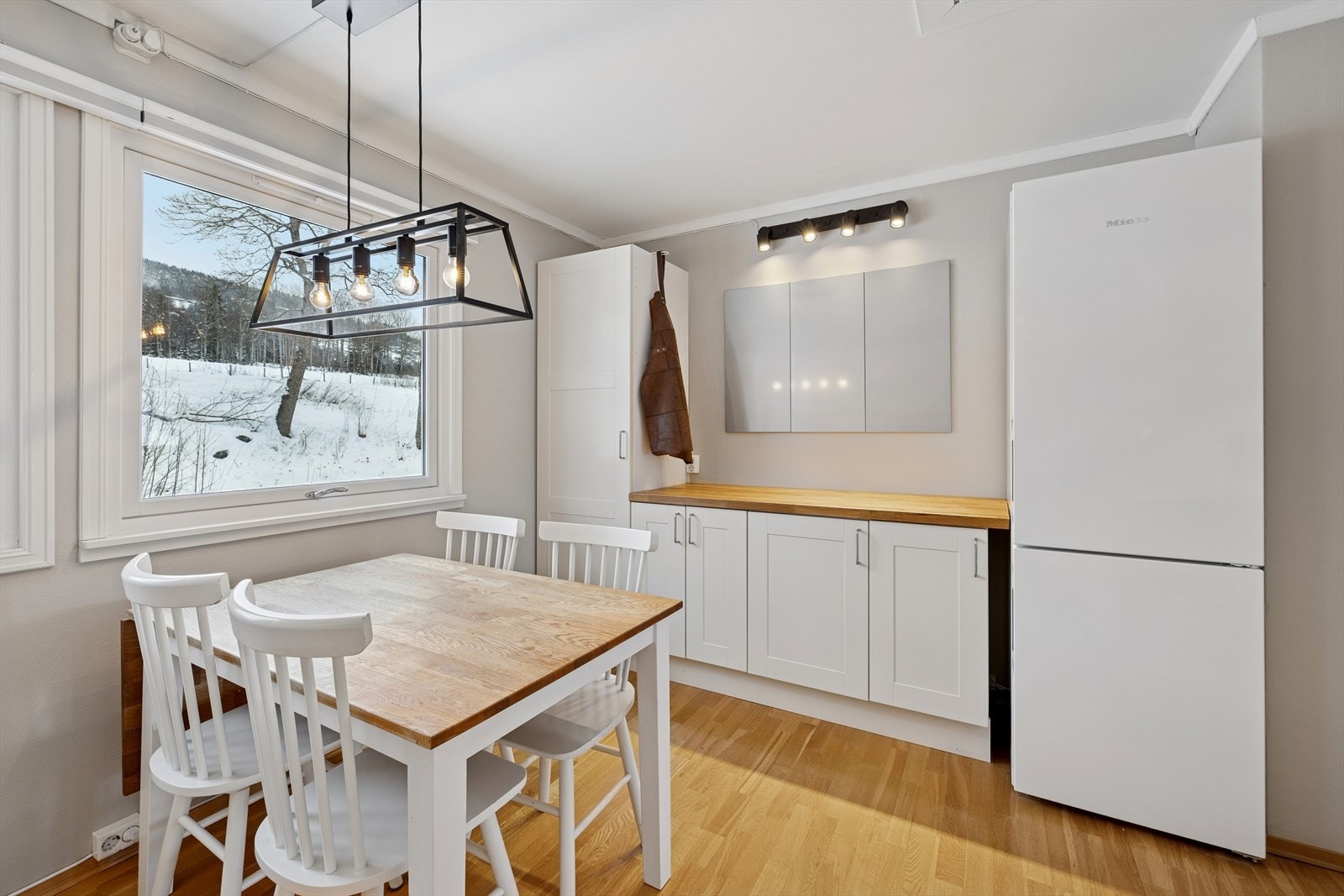 Kjøkkenet har godt med skap og benkeplass, samt plass til et lite spisebord. Galleribilde