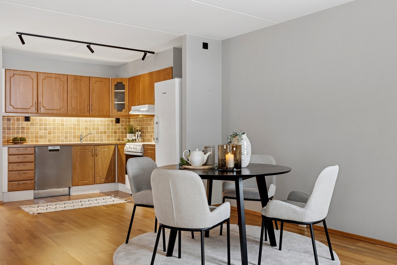 Kjøkkeninnredningen har profilerte fronter og laminatbenkeplate med fliser over arbeidsflaten. Galleribilde