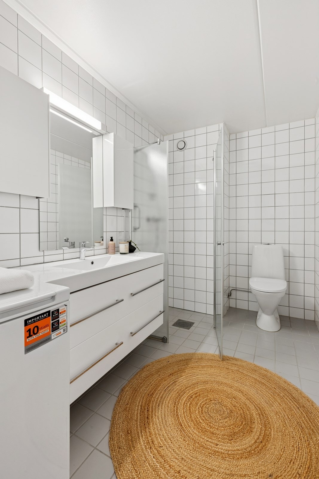 Badet er helfliset og har gulvvarme, dusjhjørne med innfellbare dører og opplegg for vaskemaskin. Galleribilde