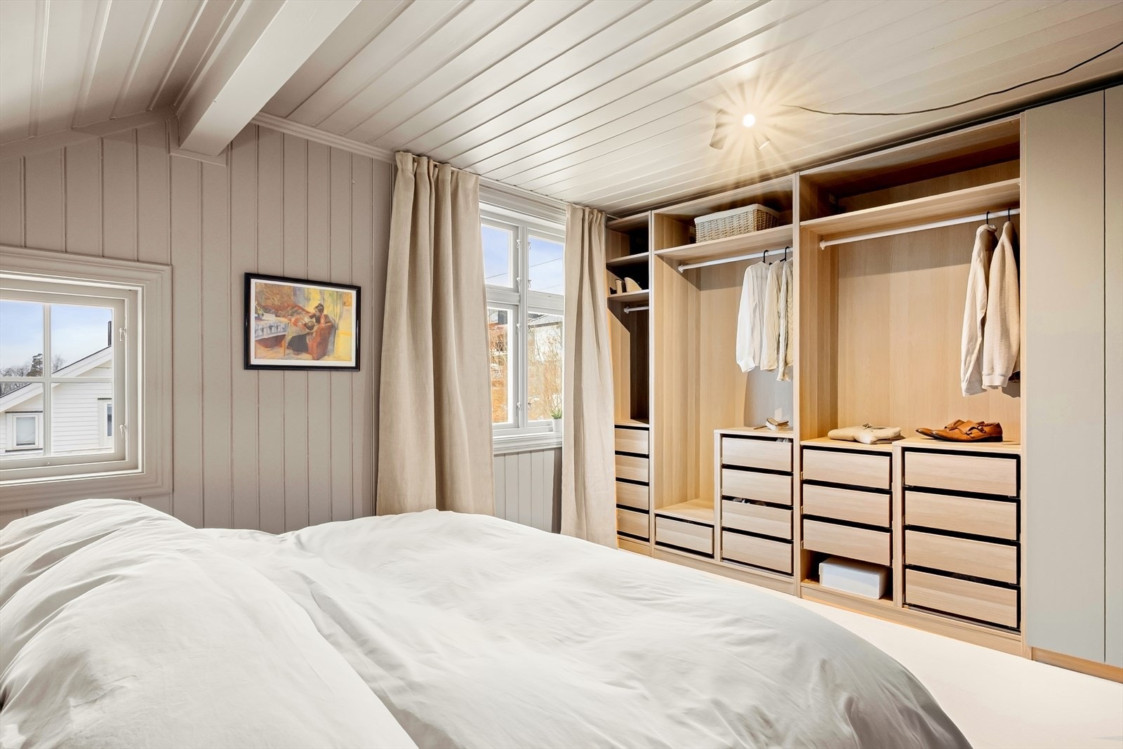 Langs den ene veggen er det et romslig, åpent garderobeskap med tilhørende lukket modul som gir gode oppbevaringsmuligheter. Galleribilde